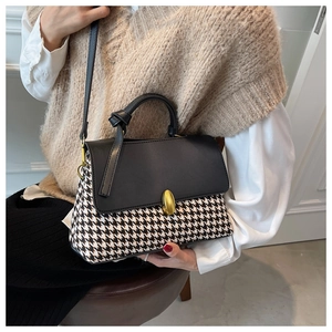 Classic houndstooth crossbody bag with gold oval clasp shown on model for outfit pairing