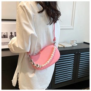 Detail of pink crescent shoulder bag with pearl accents and silver heart chain strap