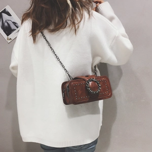 Rear view of model wearing a vintage brown crossbody bag with silver studs and chain