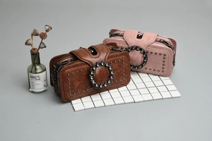 Detail of vintage crossbody bags featuring crystal buckle and metal rivet accents