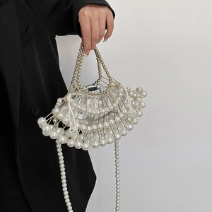 Luxury pearl beaded handbag with gold handle and silver satin lining shown on model