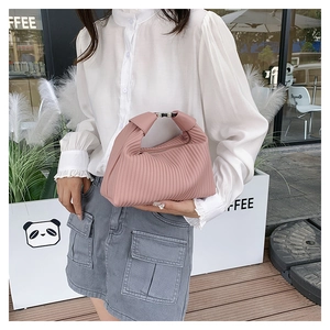 Detail of pink pleated handbag showing vertical texture and stylish crescent shape design