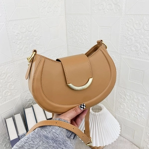 Detailed close-up of camel half-moon shoulder bag with gold hardware and adjustable strap
