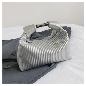 Detail of silver metallic handbag featuring vertical pleated texture and metal buckle