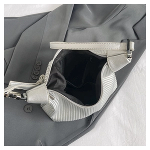 Internal view of silver pleated handbag featuring black lining and secure zipper pocket