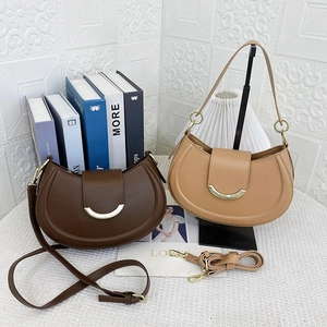 Detail view of crescent handbags with gold buckle in dark brown and khaki colors