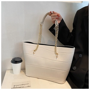 Chic beige crocodile embossed tote bag with gold chain handles for stylish urban commuting