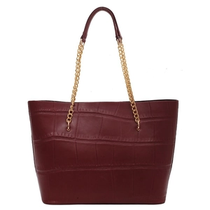 Large burgundy tote bag with crocodile texture and gold chain straps on white background