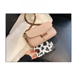 Detailed size comparison of a minimalist pink crossbody bag next to a patterned smartphone