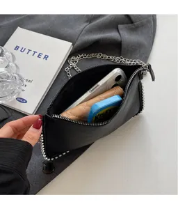 Interior view of black chain bag showing storage capacity for phone and wallet