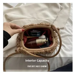 Internal capacity of khaki pleated cloud bag with red lining and cosmetic items