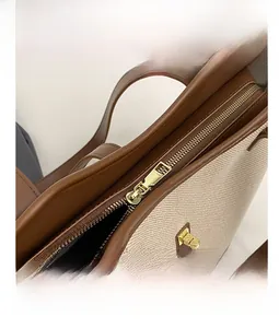 Detail shot of smooth gold zipper and contrast stitching on the canvas tote bag