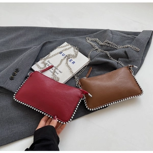 Detail of red and brown PU leather purses with silver bead trim and chain straps