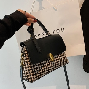 Classic houndstooth and black leather handbag with gold twist lock and top handle