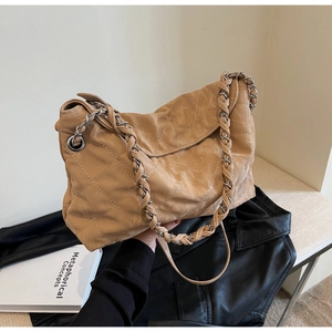 Dettaglio della borsa trapuntata kaki con tracolla a catena in metallo e texture in pelle