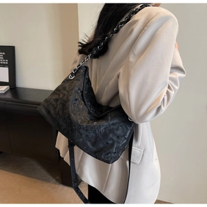 Dettaglio della borsa tote in nylon trapuntata con catena in metallo e tracolla in pelle