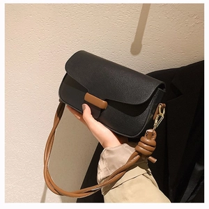 Minimalist black and brown contrast leather crossbody bag with creative knotted strap