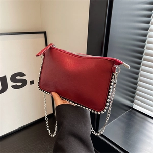 Red leather pillow bag with silver rivets and metal chain strap for women's crossbody wear