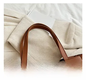 Détail du sac à main en similicuir marron montrant les coutures et la texture du cuir