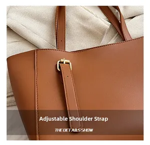 Détail de la bandoulière réglable en cuir sur un sac fourre-tout marron avec boucle en métal