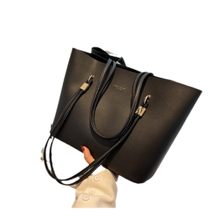 Minimalist black PU leather tote bag with white contrast stitching and long shoulder straps