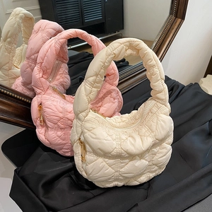 Quilted bubble shoulder bags in beige and pink shown on silk fabric with mirror reflection