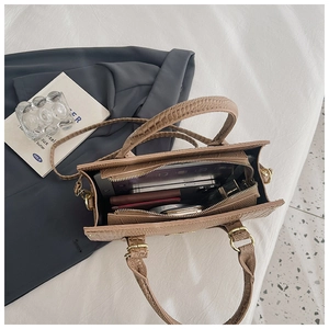 Overhead view showing storage capacity of brown crocodile texture handbag with accessories