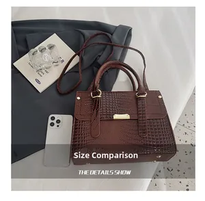 Size comparison of dark brown crocodile pattern handbag with white smartphone detail