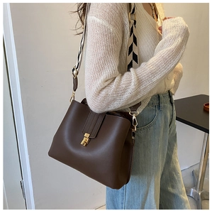 Detailed close-up of brown PU leather bag with black and white wavy wide strap