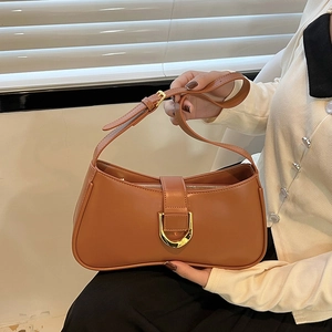 Detail of a brown vintage leather shoulder bag with a gold D-ring buckle and strap