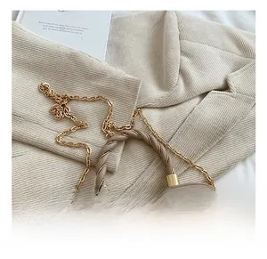 Detail of a brown pleated PU leather crossbody bag with a braided handle and gold chain