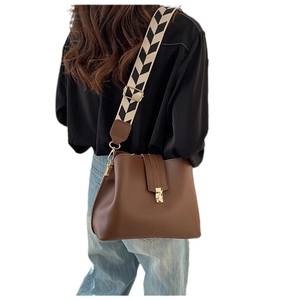 Chic brown leather shoulder bag featuring a stylish black and white woven strap for women