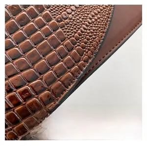 Macro detail of dark brown crocodile-embossed PU leather with glossy oil wax finish