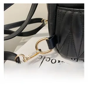 Close-up of premium gold-toned metal hook and black quilted leather texture on handbags