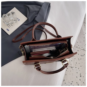 Brown crocodile pattern handbag showing spacious interior for tablet and cosmetics
