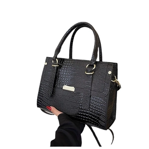 Black crocodile embossed handbag with gold rings and a structured rectangular shape