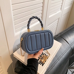 Blue quilted leather crossbody bag with twisted top handle and gold chain strap