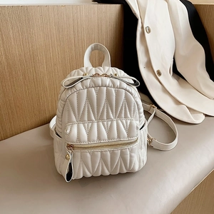 White quilted mini backpack with V-pattern stitching and gold-toned hardware details