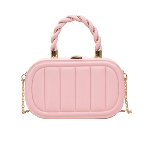Detail view of pink quilted handbag with gold chain strap and twisted top handle