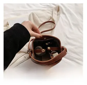 Vue détaillée de la grande capacité intérieure d'un sac seau en cuir marron avec fermoir