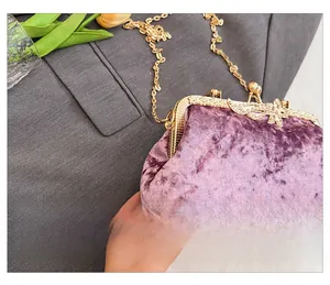 Detail of purple velvet evening clutch with gold butterfly clasp and chain strap
