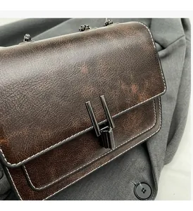 Macro detail of brown retro leather texture and gunmetal buckle on shoulder bag