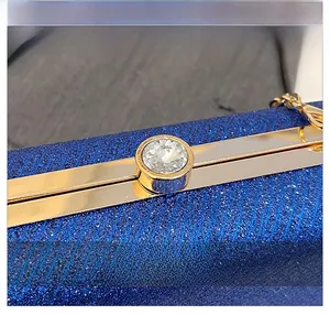 Macro shot of sparkling blue sequin clutch bag featuring a gold rhinestone clasp detail