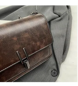 Detailed macro of vintage brown leather bag texture with metal buckle and chain strap