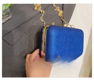 Side view of blue glitter hard shell clutch with gold metal trim and long chain strap
