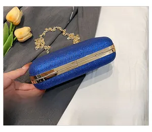 Close-up of the royal blue glitter evening clutch bottom with gold metal hardware