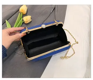 Detail show of blue sequin clutch bag interior with golden chain strap and rhinestones
