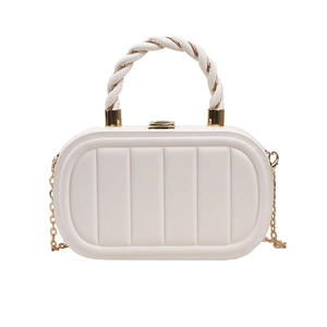 Detail of white quilted crossbody bag featuring a gold twisted handle and chain strap