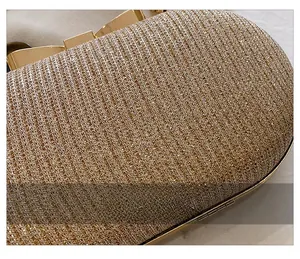 Détail macro du tissu pailleté doré et du fermoir en forme de nœud de cette pochette