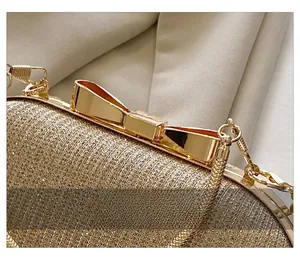 Gros plan sur le fermoir doré en forme de nœud et la texture scintillante de la pochette